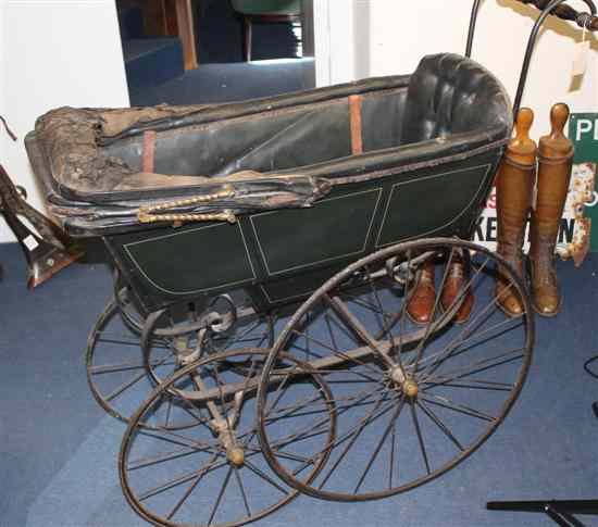 Appraisal: A Victorian wrought iron and leather pram with graduated wheels