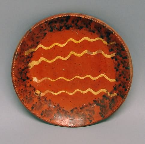 Appraisal: Three wavy lines mottled outer border redware ground coggled rim