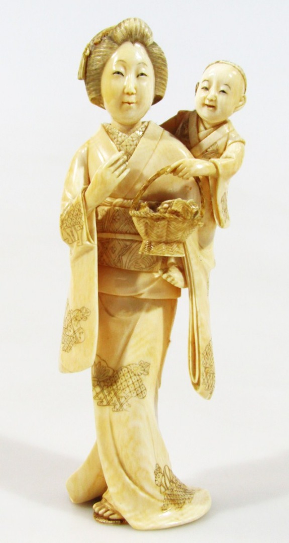 Appraisal: A thC Japanese carved ivory figure group formed as a