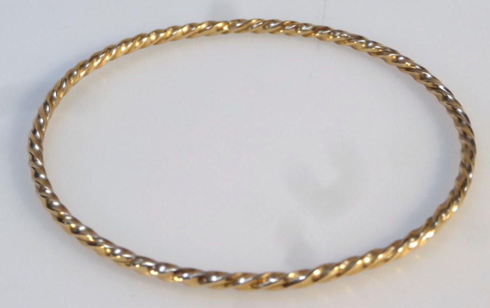 Appraisal: A twist bangle with circular body yellow metal marked cm