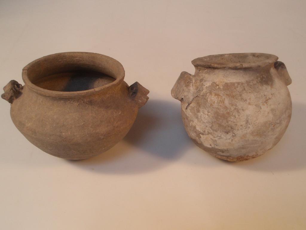 Appraisal: Two ancient blackened cooking pots the first with a bulbous