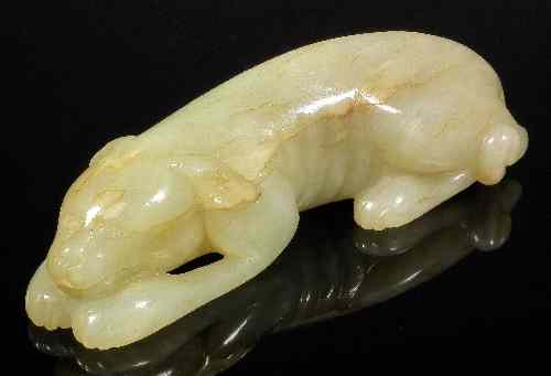 Appraisal: A Chinese celadon jade carving of a reclining dog in