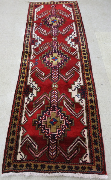 Appraisal: PERSIAN RUNNER hand knotted in a three geometric medallion design