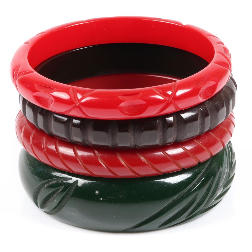 Appraisal: BAKELITE FOUR CARVED BANGLE BRACELETS IN CHERRY RED GREEN AND