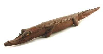 Appraisal: A carved wood model of a crocodile with cowrie shell