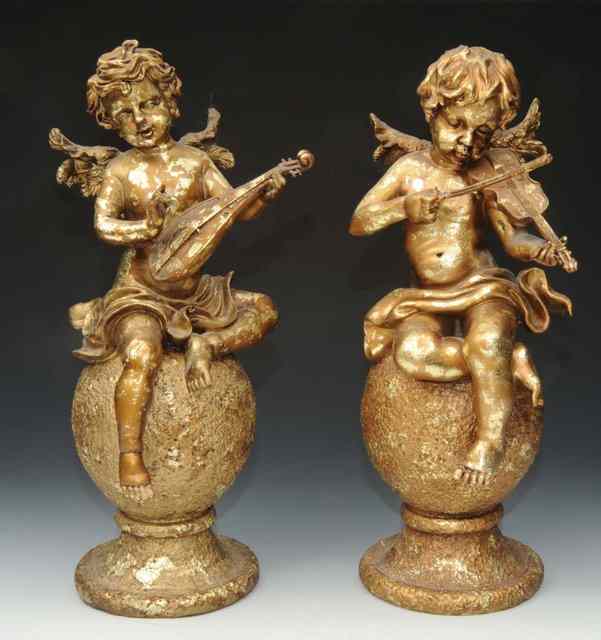 Appraisal: A PAIR OF PLASTER CHERUB MUSICIANS on bulbous supports one