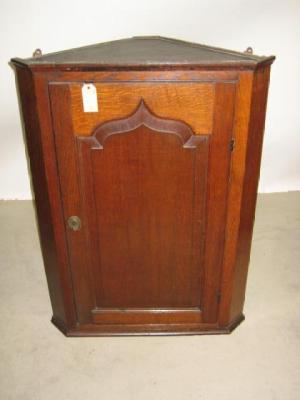 Appraisal: A GEORGE III OAK CORNER CUPBOARD the moulded cornice over