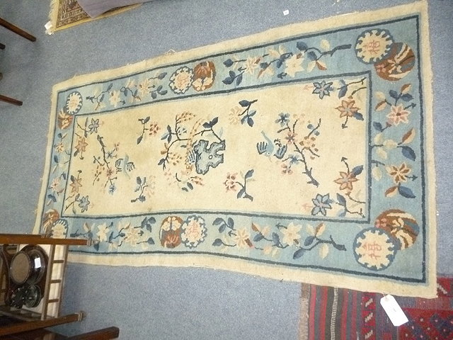 Appraisal: A CHINESE CREAM GROUND RUG decorated within blossom in the