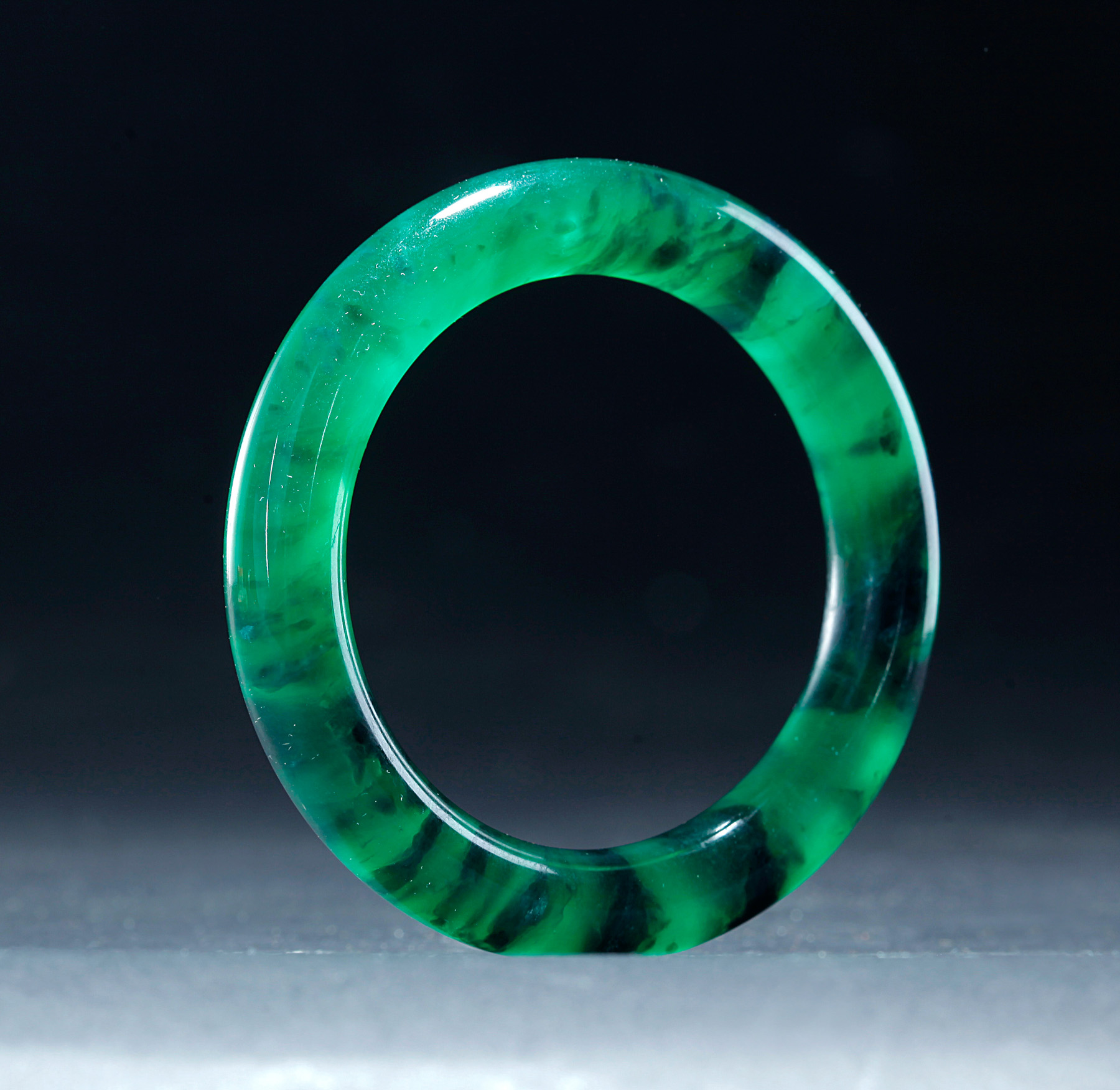 Appraisal: CHINESE JADEITE BANGLE Nineteenth century Smooth polished translucent Spanish green