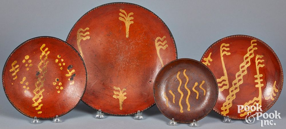 Appraisal: Four Pennsylvania slip decorated redware plates Four Pennsylvania slip decorated