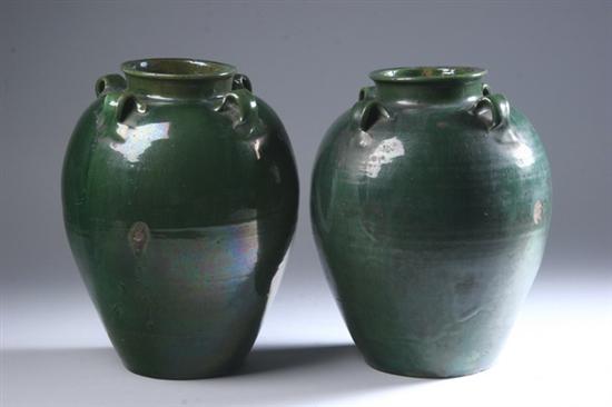 Appraisal: PAIR CHINESE GREEN GLAZED STONEWARE JARS Each with loop-form handles