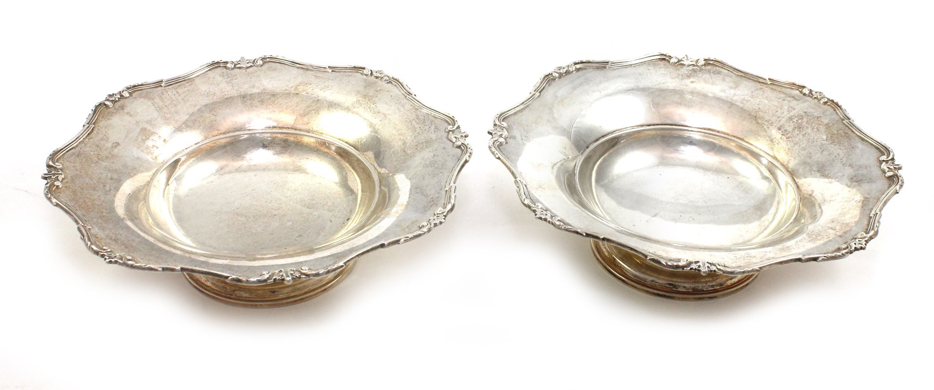 Appraisal: A pair of silver dishes each decorated with a scrolling