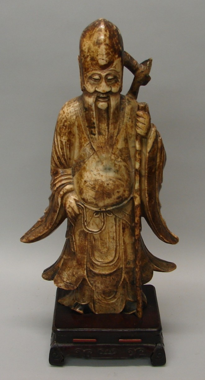 Appraisal: Full length figure wearing long robe and holding walking stick