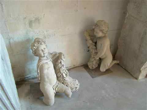 Appraisal: PAIR OF TINTED PLASTER CHERUBS holding berried laurel swags -