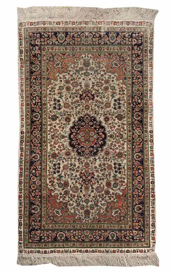 Appraisal: A Kirman Wool and Silk Rug centered with a floral