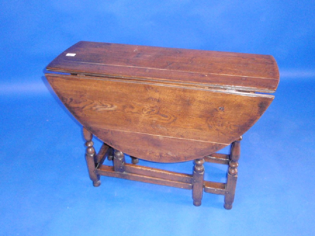 Appraisal: An oak gate leg table in thC style with turned