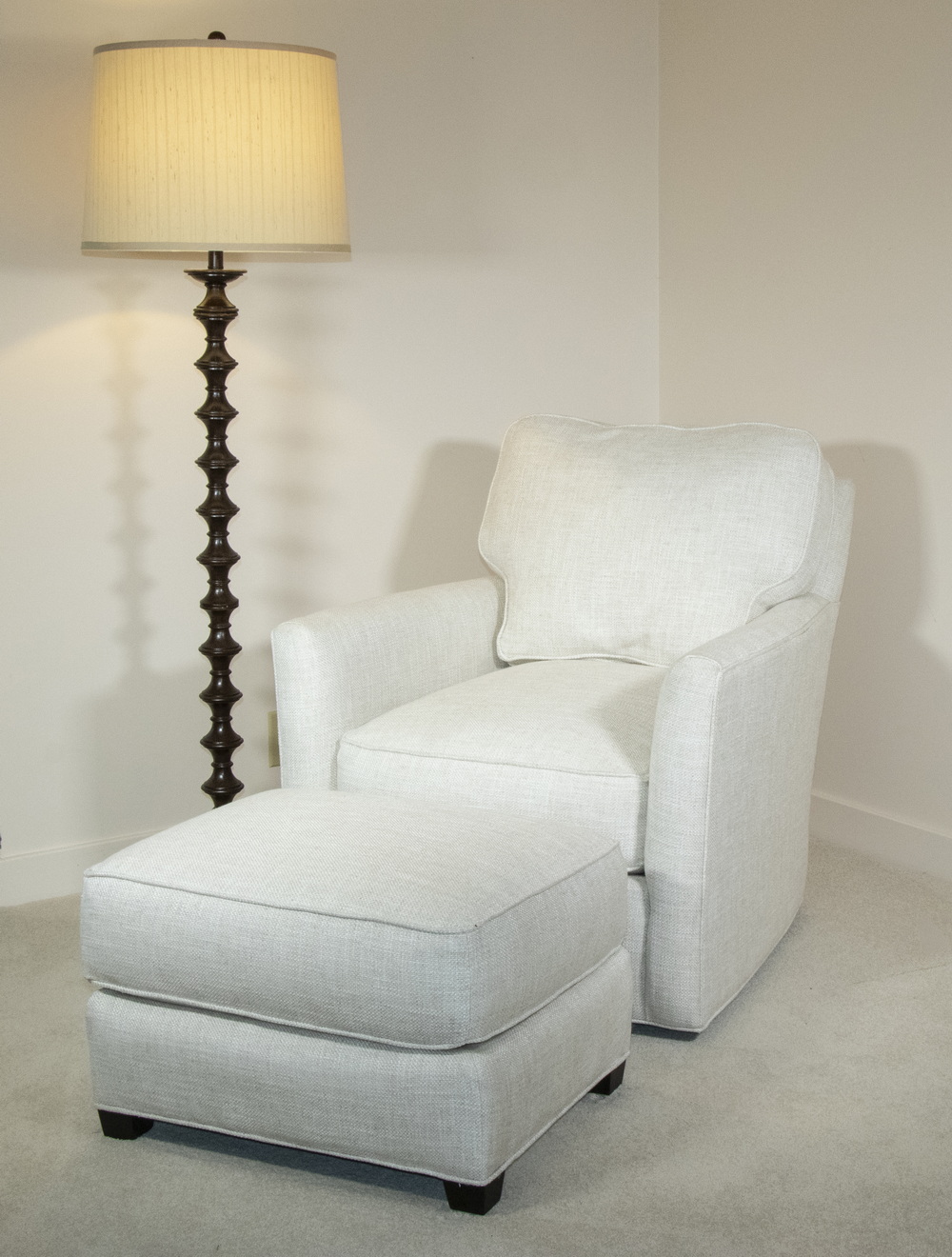 Appraisal: WHITE ARMCHAIR ON SWIVEL BASE WITH MATCHING OTTOMAN White upholstered