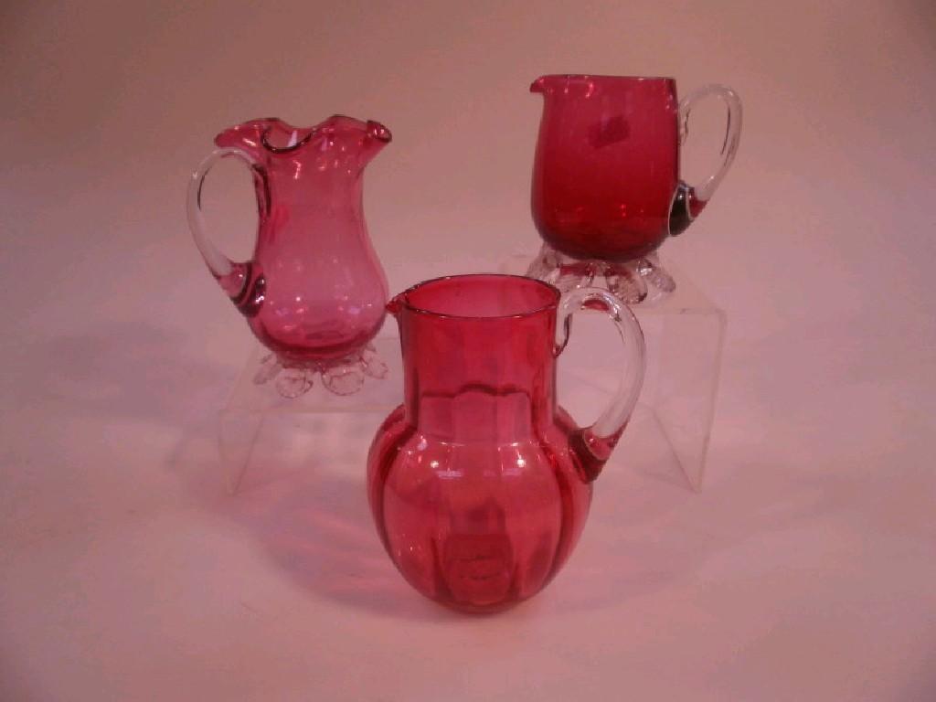 Appraisal: Three Cranberry glass jugs