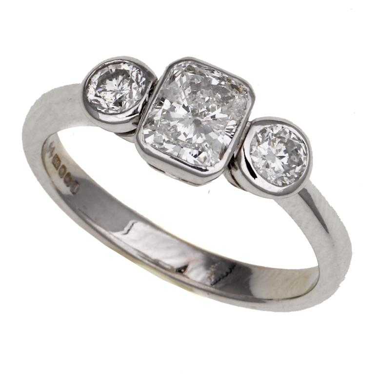 Appraisal: A DIAMOND THREE-STONE RING the larger central collet set oblong