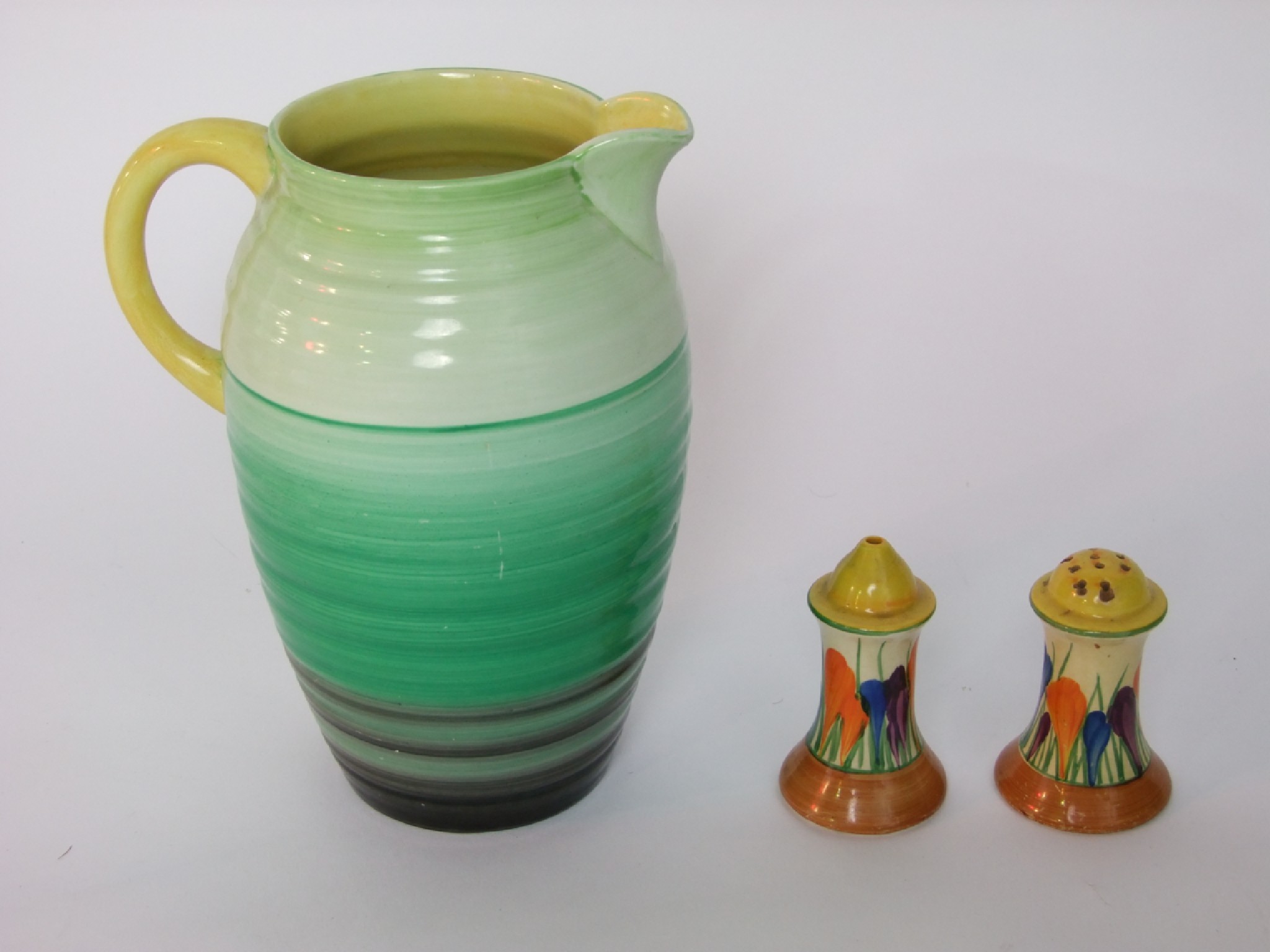 Appraisal: A pair of Clarice Cliff condiments with orange purple and