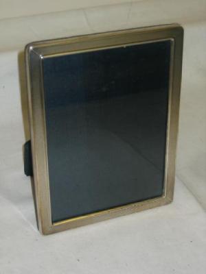 Appraisal: A PHOTOGRAPH FRAME of rounded oblong engine turned form with