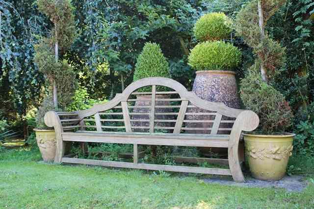 Appraisal: A LUTYENS STYLE TEAK GARDEN SEAT with camel back and