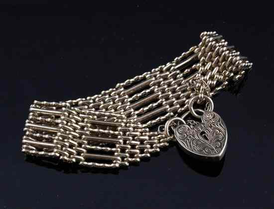 Appraisal: A ct gold seven bar gatelink bracelet with heart padlock