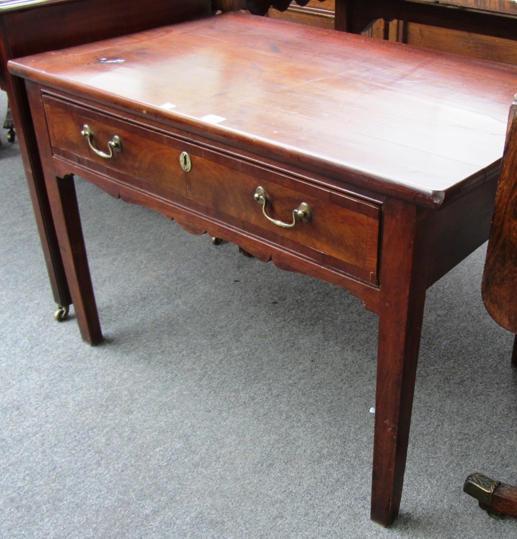 Appraisal: An th century mahogany low single drawer table on tapering