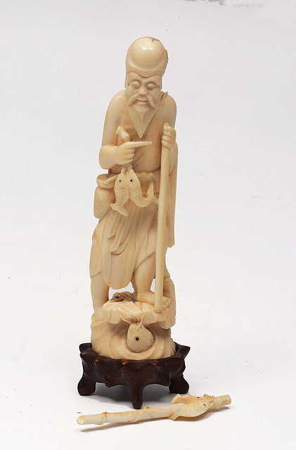 Appraisal: A CHINESE CARVED IVORY MODEL OF A FISHERMAN on a