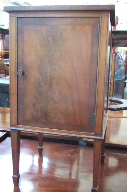 Appraisal: An Edwardian mahogany pot cupboard with single door raised on