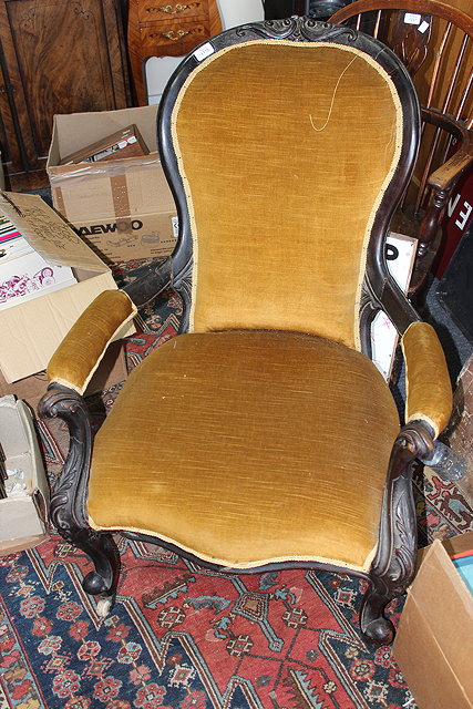 Appraisal: A LATE VICTORIAN WALNUT FRAMED EBONISED OPEN ARMCHAIR with pad