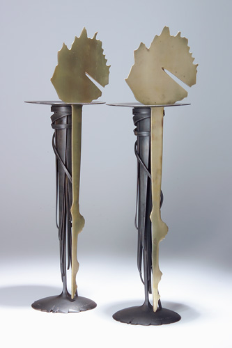 Appraisal: ALBERT PALEY Pair of Sunrise tall candlesticks of forged milled