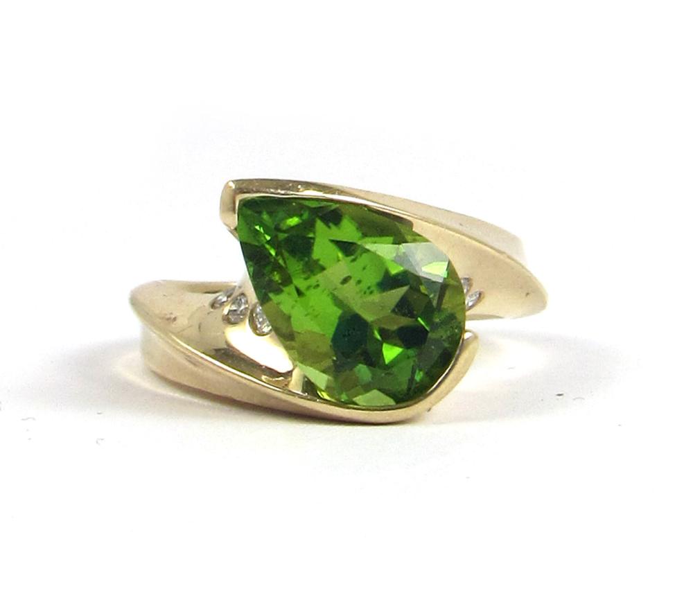 Appraisal: PERIDOT DIAMOND AND FOURTEEN KARAT GOLD RING with three round-cut