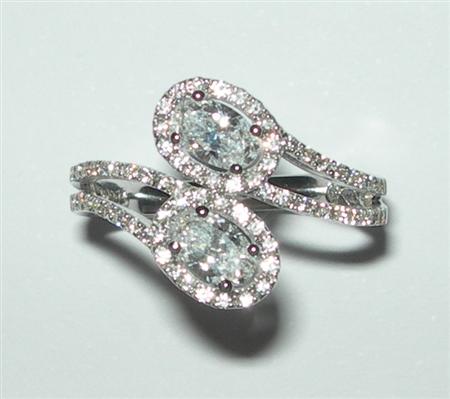 Appraisal: A modern diamond cluster ring of cross-over design claw set