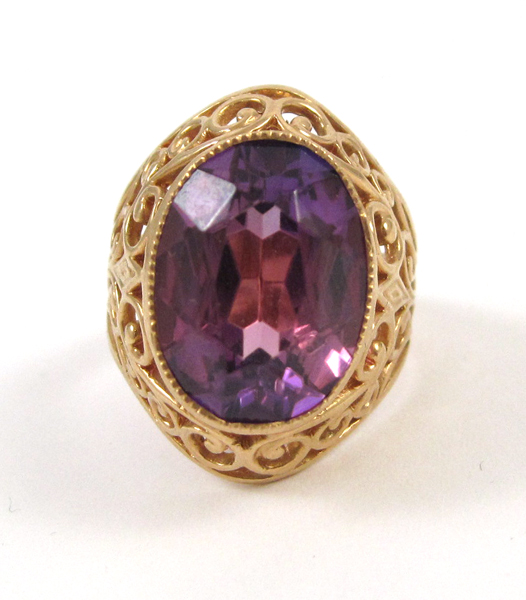 Appraisal: FOURTEEN KARAT ROSE GOLD RING featuring an oval-cut reddish purple