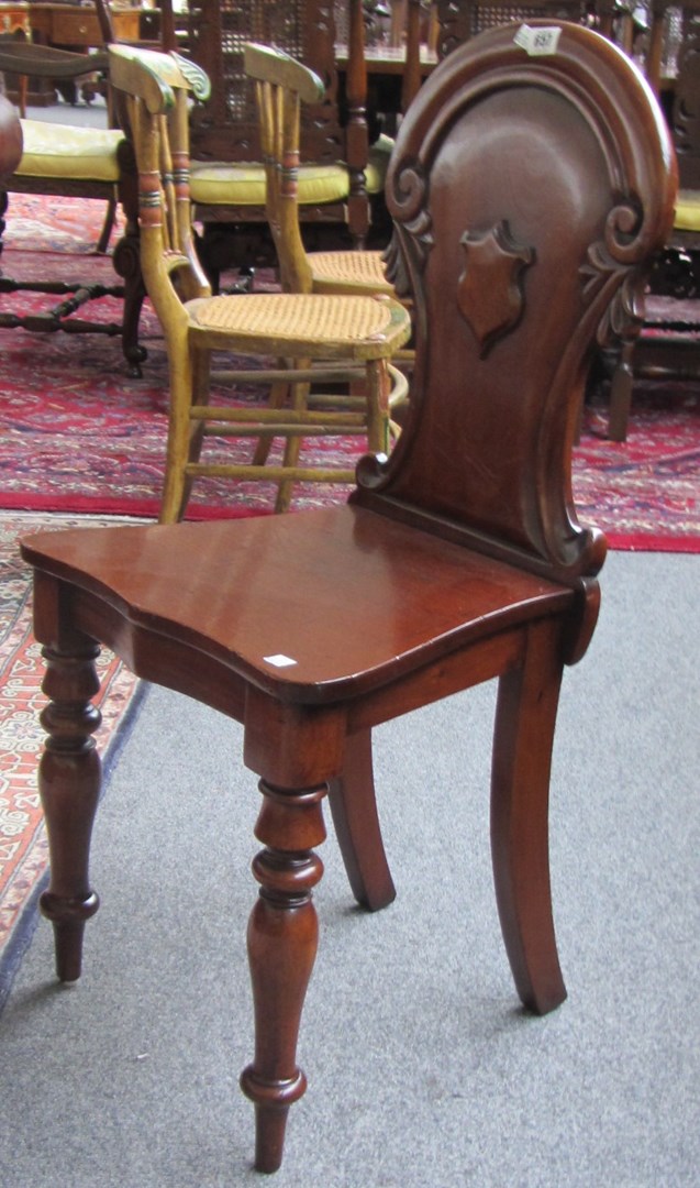 Appraisal: A pair of Victorian mahogany hall chairs with shield carved