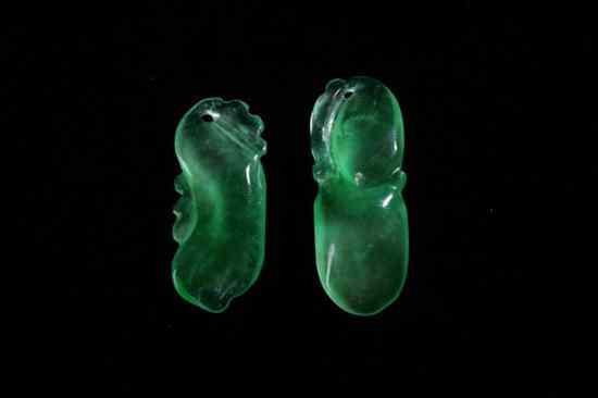 Appraisal: TWO CHINESE APPLE GREEN JADEITE PENDANTS Carved to depict a