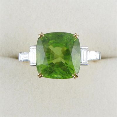 Appraisal: A peridot and diamond ring Cushion shaped peridot is set