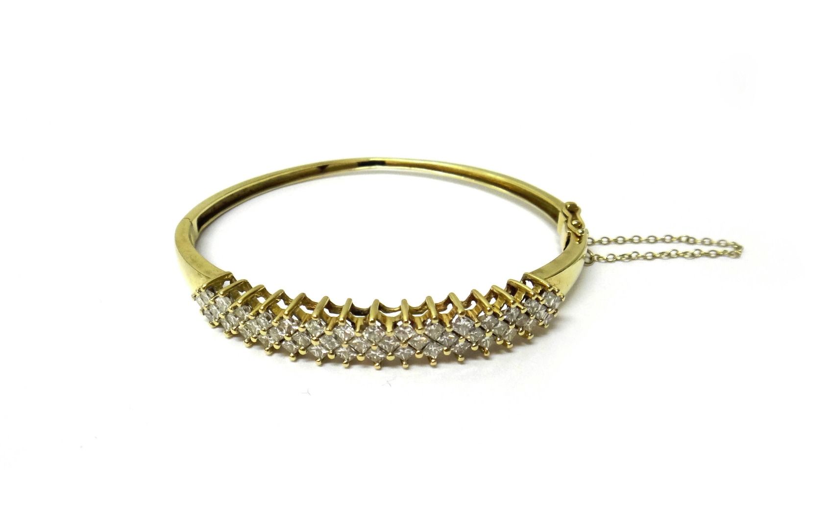 Appraisal: A gold and diamond set oval hinged bangle the front