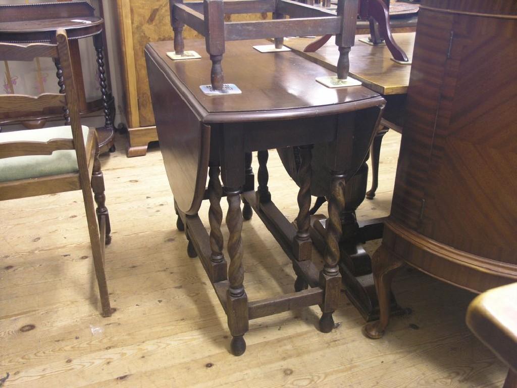 Appraisal: A solid dark oak gateleg table on barley-twist underframe with