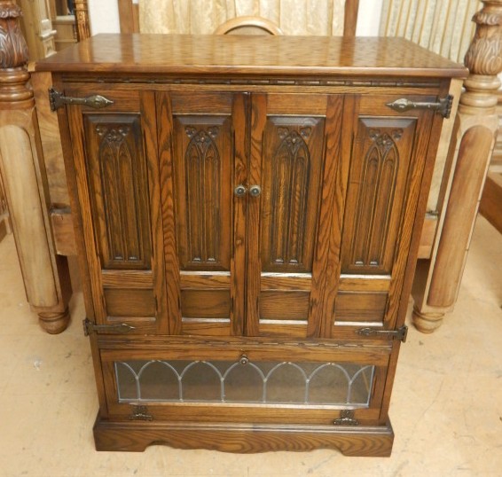 Appraisal: An Old Charm oak television cabinet with hinged doors carved