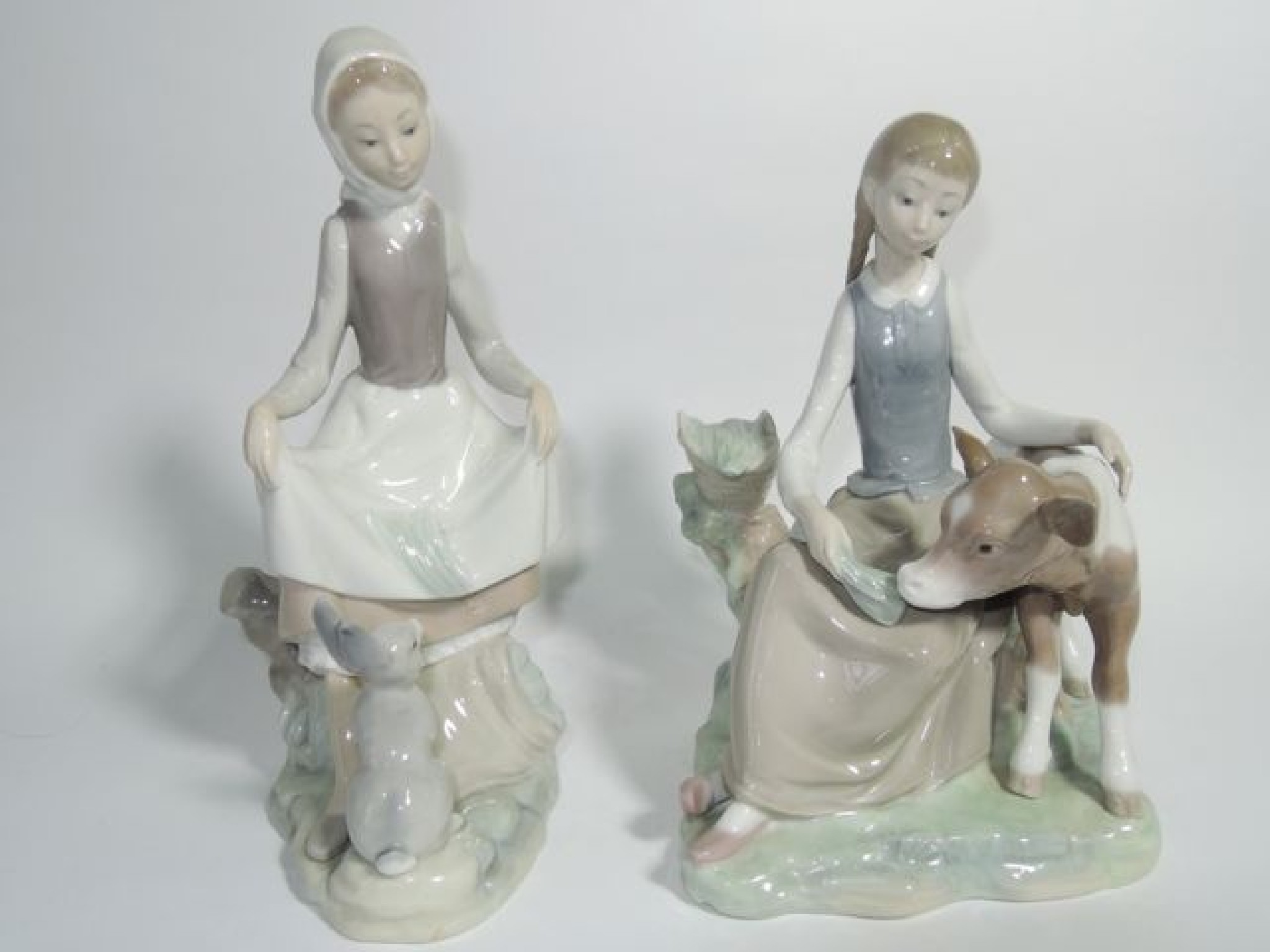 Appraisal: Two Lladro figure groups one of a girl feeding a