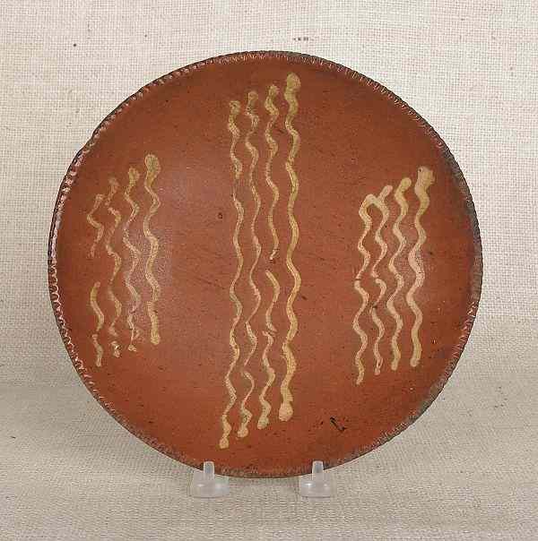 Appraisal: Pennsylvania redware pie plate th c with yellow slip squiggle