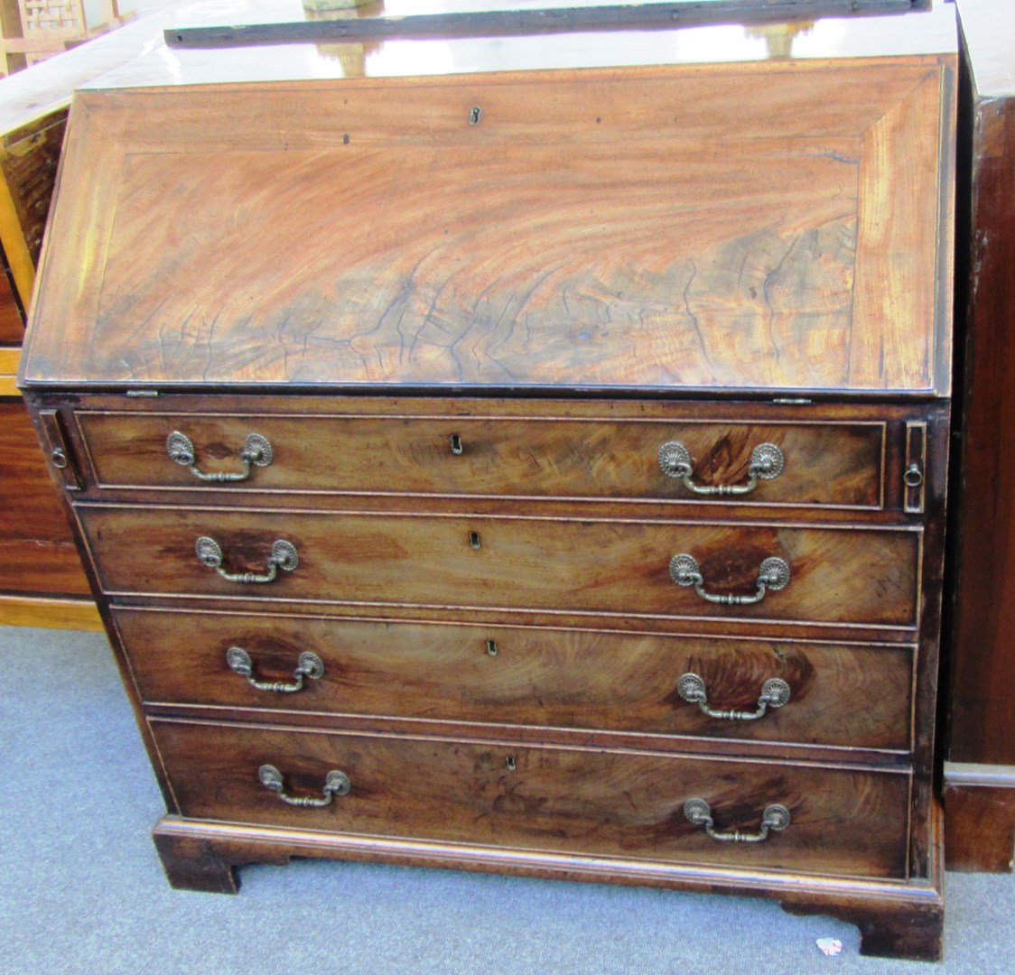 Appraisal: A George III mahogany bureau the fall over four long