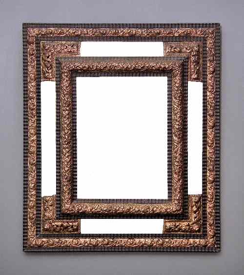 Appraisal: An ebonised and repousse gilt metal framed rectangular wall mirror