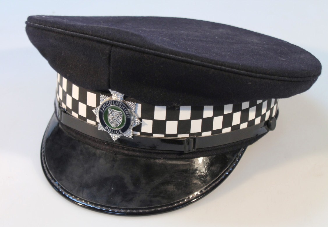 Appraisal: A standard issue Lincolnshire police peak cap with Lincoln badge