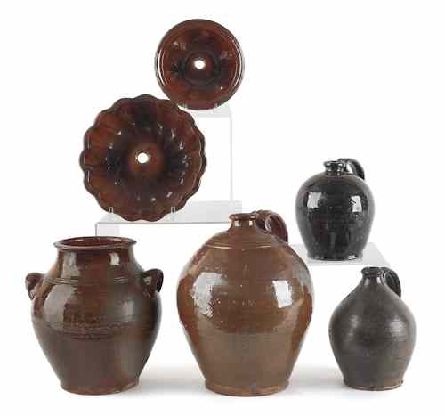 Appraisal: Three Pennsylvania redware jugs th c together with a crock