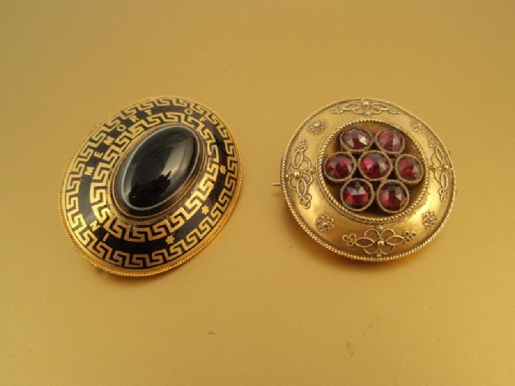 Appraisal: A Victorian circular memorial brooch set with seven faceted garnets