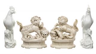 Appraisal: A BLANC-DE-CHINE GROUP OF TWO LIONS AND TWO ROOSTERS comprising