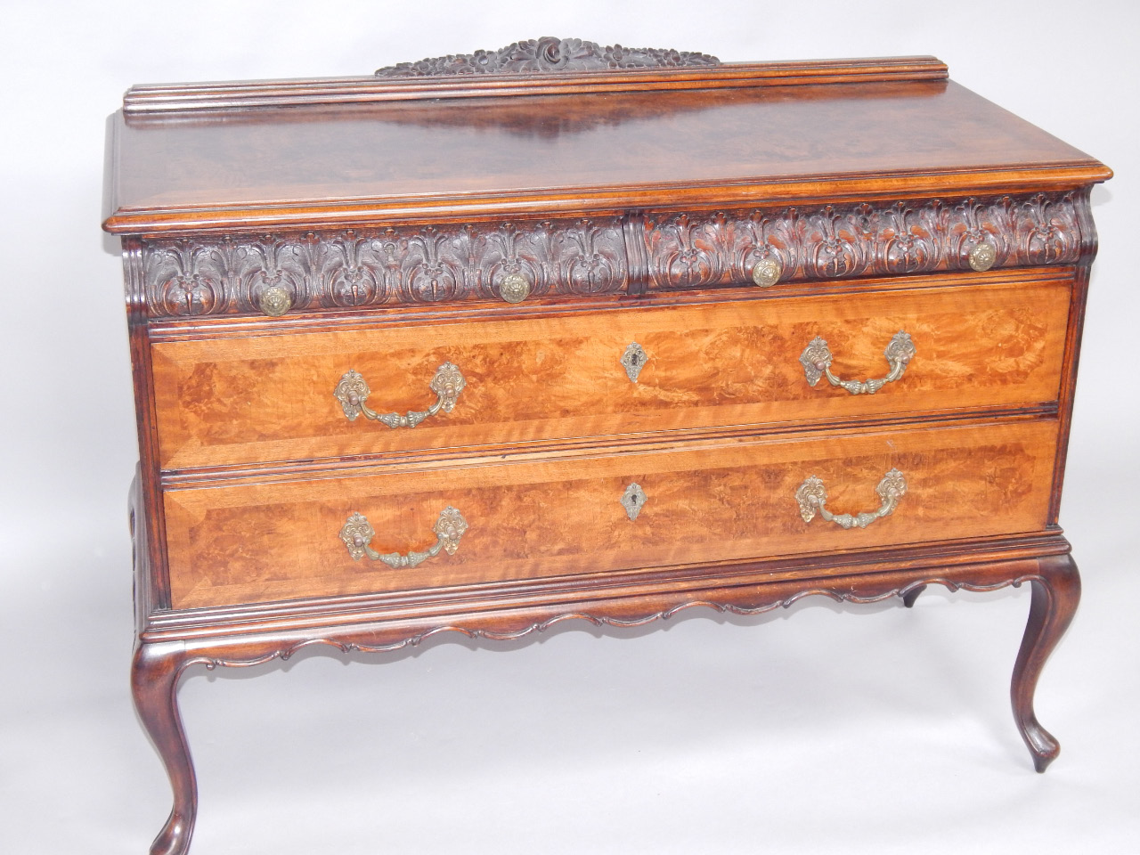 Appraisal: An oak and burr walnut chest with one carved cushion